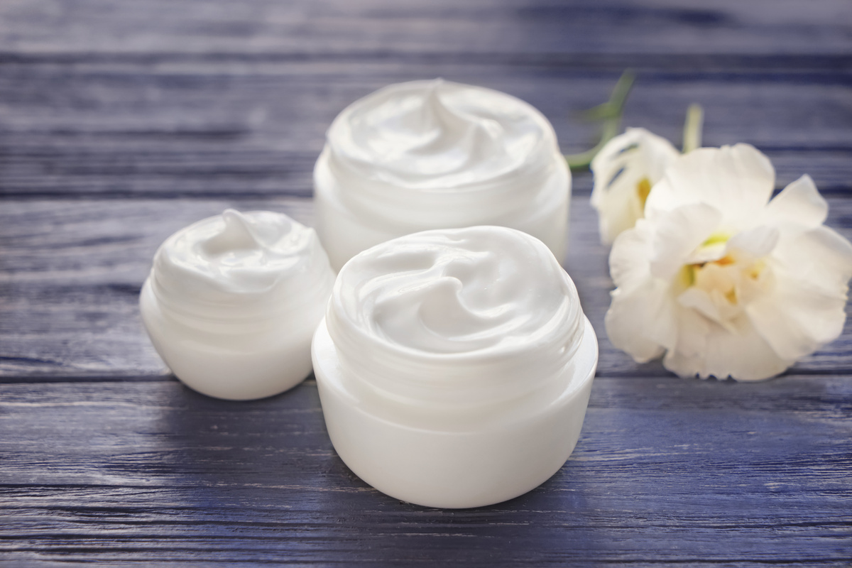 Jars with Body Cream on Wooden Table
